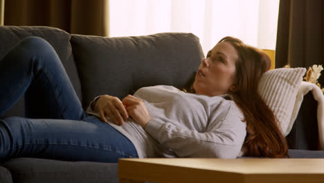 Woman-Lying-On-Sofa-At-Home-Fed-Up-And-Bored-With-Time-Wasted-Using-Mobile-Phone-To-Check-Social-Media-Message-And-Scroll-Online-1